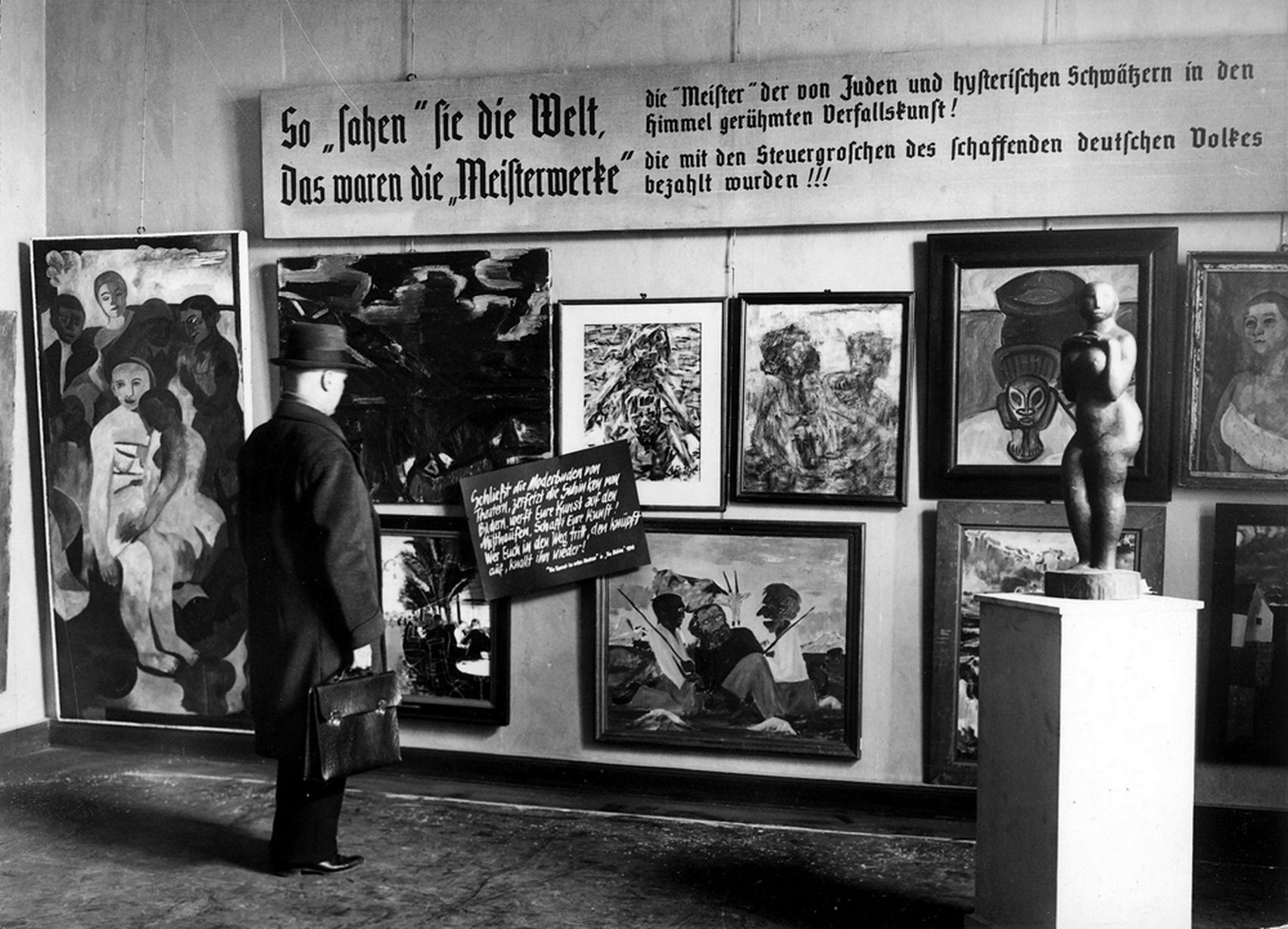 A-man-looks-at-pieces-from-the-Nazi-curated-travelling-exhibition-Degenerate-Art-Entartete-Kunst-at-its-second-stop-at.jpg