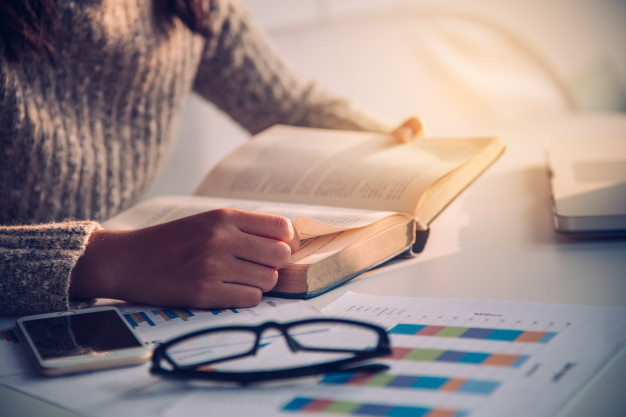 focus-hand-open-book-reading-desk-work-with-gold-lighting-morning_11304-693.jpg