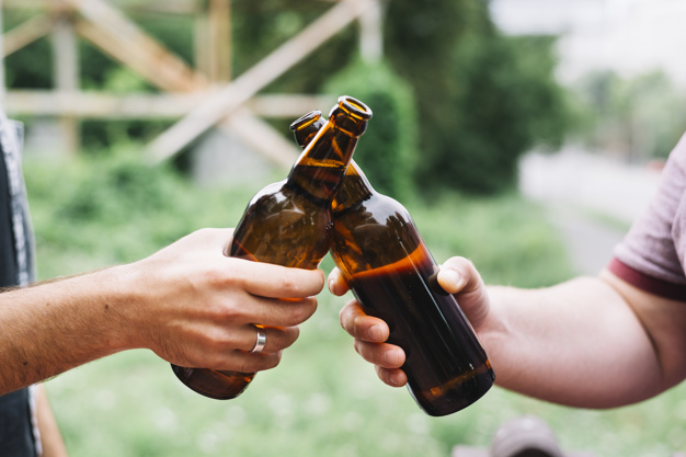 close-up-friend-s-hand-toasting-brown-beer-bottles-outdoors_23-2147919169.jpg
