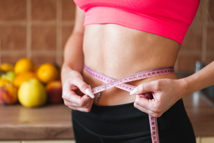 young-slim-woman-measuring-her-waist-by-measure-tape-picjumbo-com.jpg